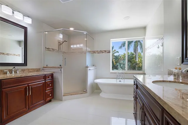 a bathroom with a sink double vanity mirror and a bathtub