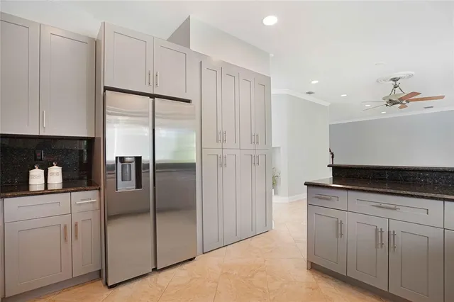 a kitchen with granite countertop white cabinets and refrigerator