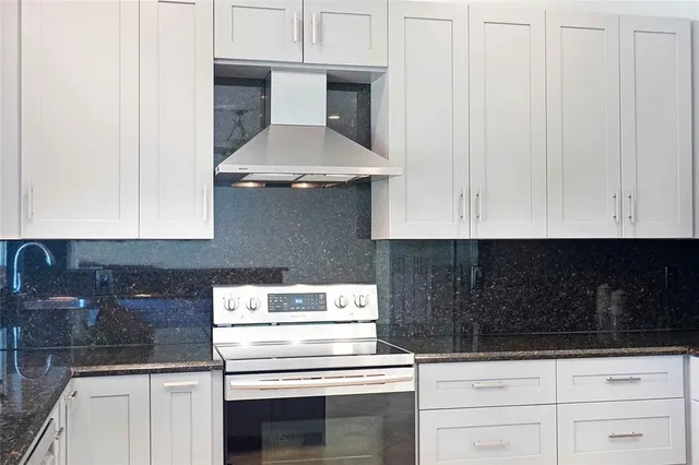 a kitchen with a stove and white cabinets