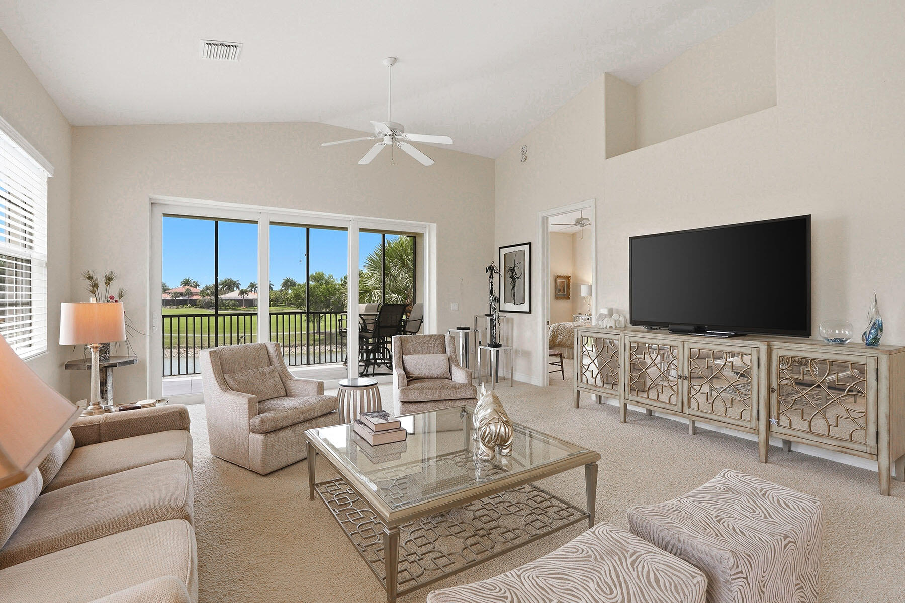 8605 Champions Point, Unit 103 Naples, FL 34113 - Photo 17 of 44 a living room with furniture a flat screen tv and a large window