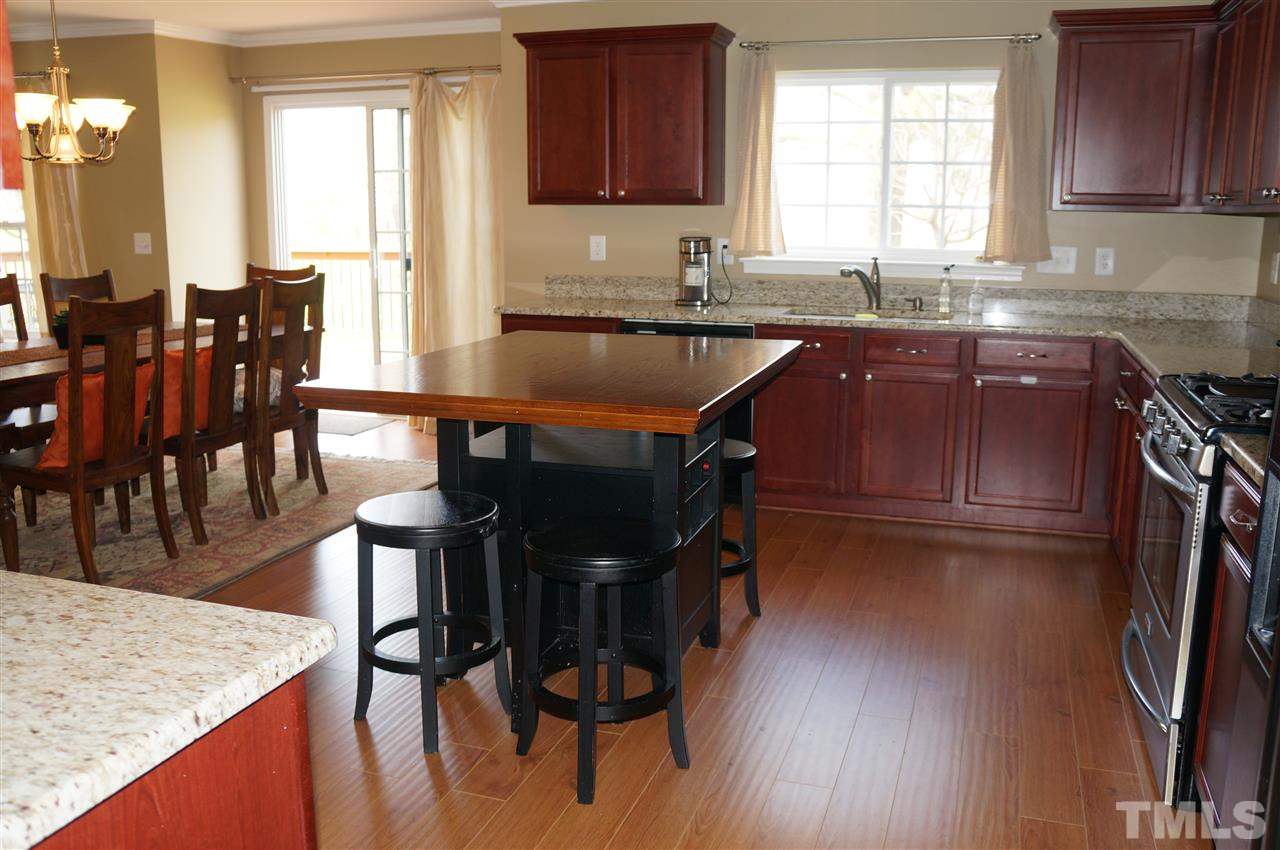 177 Ryder Cup Circle Raleigh, NC 27603 - Photo 8 of 25 View from entering from the garage. This kitchen has fabulous cabinet and counter space plus a pantry too! You'll love the wide plank wood floors too!