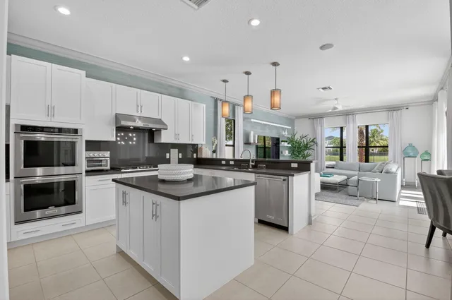 a kitchen with white cabinets and appliances