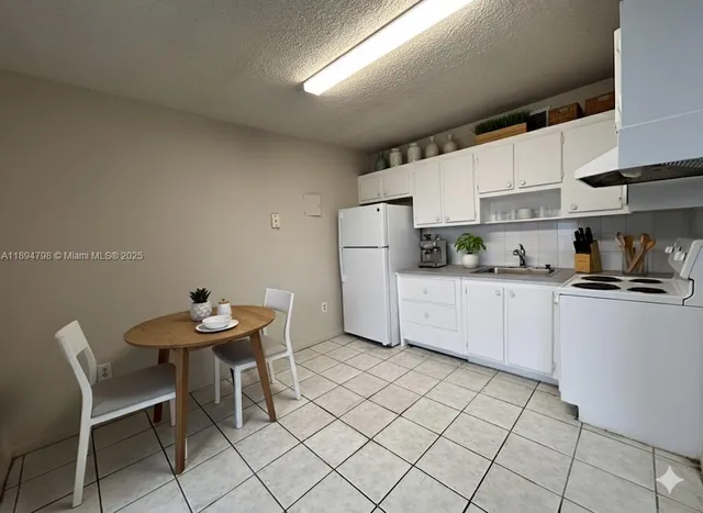 a kitchen with a sink a table and chairs