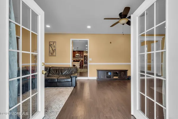 a kitchen with stainless steel appliances granite countertop a stove top oven a sink a dining table and chairs with wooden floor
