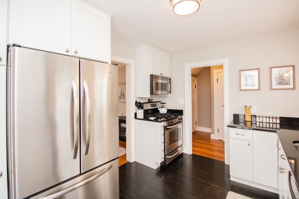 66 Howitt Road Boston, MA 02132 - Photo 3 of 24 a kitchen with stainless steel appliances a refrigerator and a stove top oven