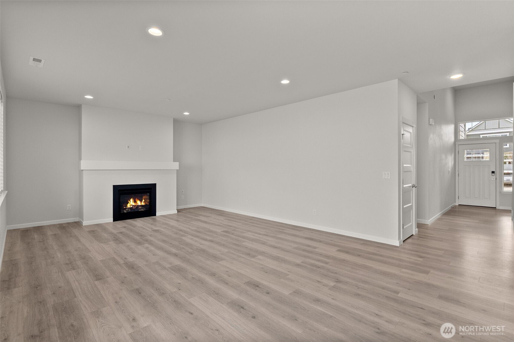 9116 Carlos Way Northeast Lacey, WA 98516 - Photo 11 of 34 a view of an empty room with wooden floor and a fireplace