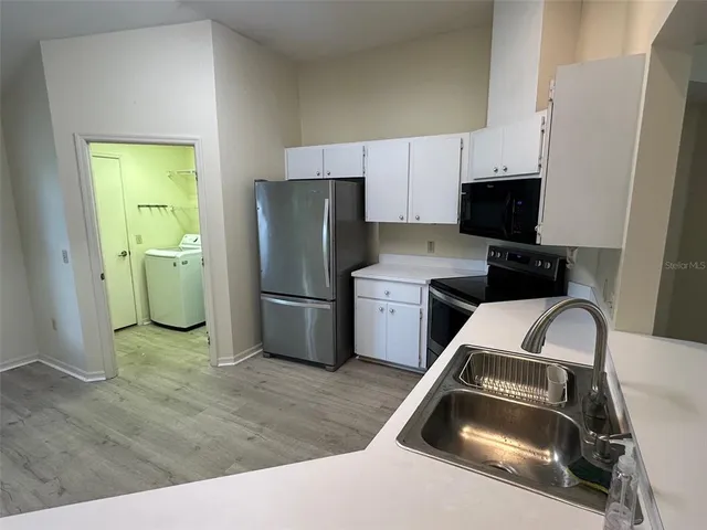 a kitchen with a refrigerator and a sink