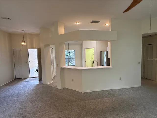 a view of an empty room with window and cabinet