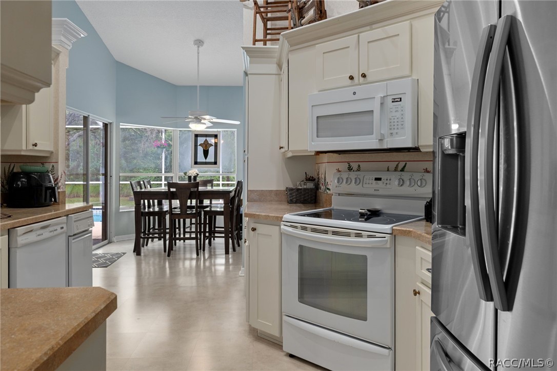 2460 West Pine Ridge Boulevard Beverly Hills, FL 34465 - Photo 10 of 47 a kitchen with white cabinets and stainless steel appliances