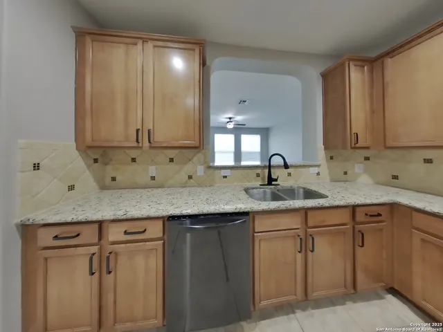 a kitchen with granite countertop cabinets sink and cabinets