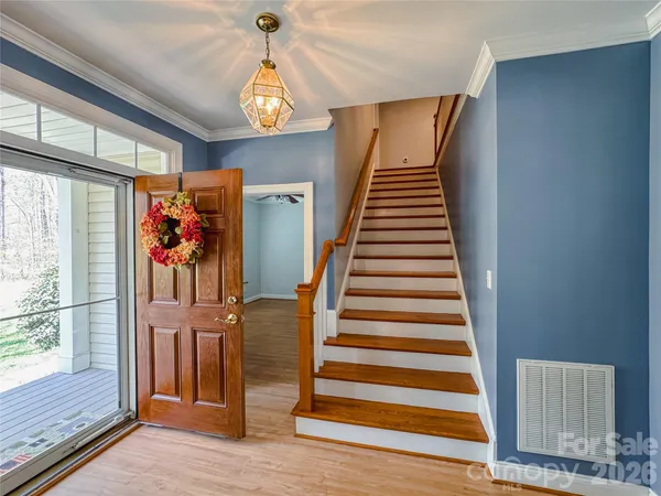 a view of a hallway with wooden floor and windows