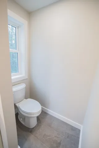 a white toilet sitting next to a window
