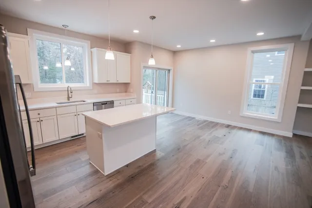a kitchen with a sink wooden floor and view living room
