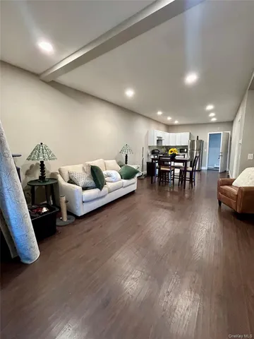 a living room with furniture and a dining table with wooden floor