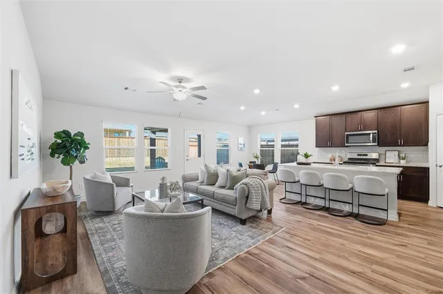 a living room with furniture and view of kitchen