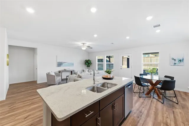 a kitchen with sink a dining table and chairs