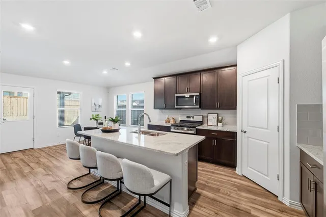 a kitchen with a table chairs refrigerator and microwave