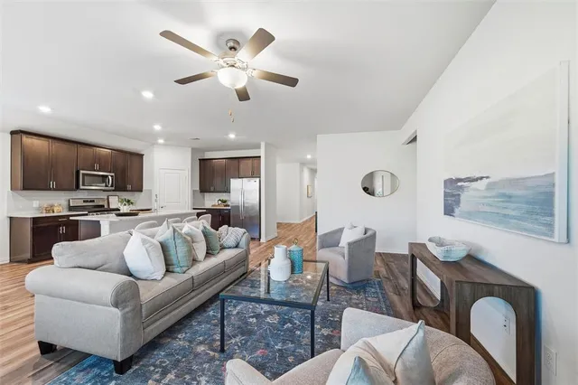 a living room with furniture kitchen view and a flat screen tv