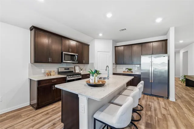a kitchen with stainless steel appliances granite countertop sink stove top oven and cabinets