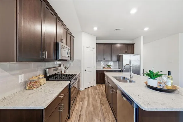 a kitchen with granite countertop stainless steel appliances and wooden cabinets
