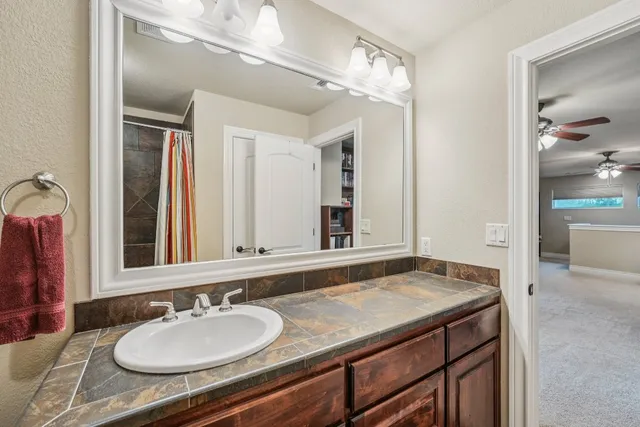 a bathroom with a granite countertop sink and a mirror