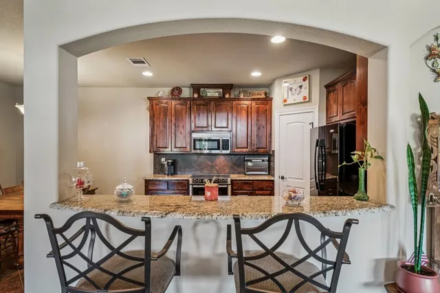a kitchen with a table chairs refrigerator and cabinets