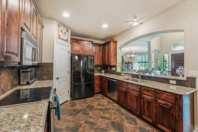 a kitchen with stainless steel appliances granite countertop a refrigerator and a sink