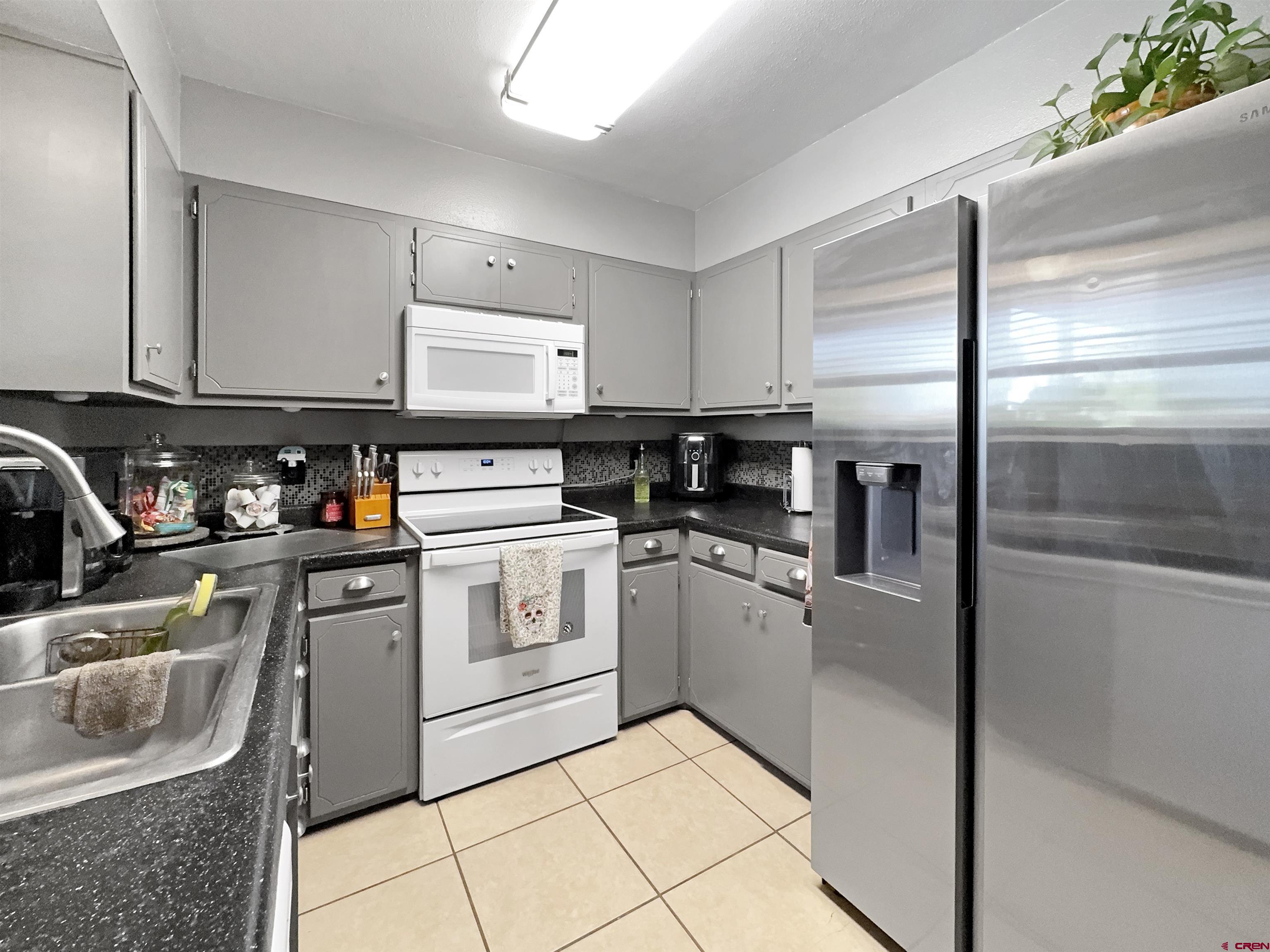 8 West 10th Street Cortez, CO 81321 - Photo 12 of 24 a kitchen with stainless steel appliances granite countertop a sink stove and refrigerator