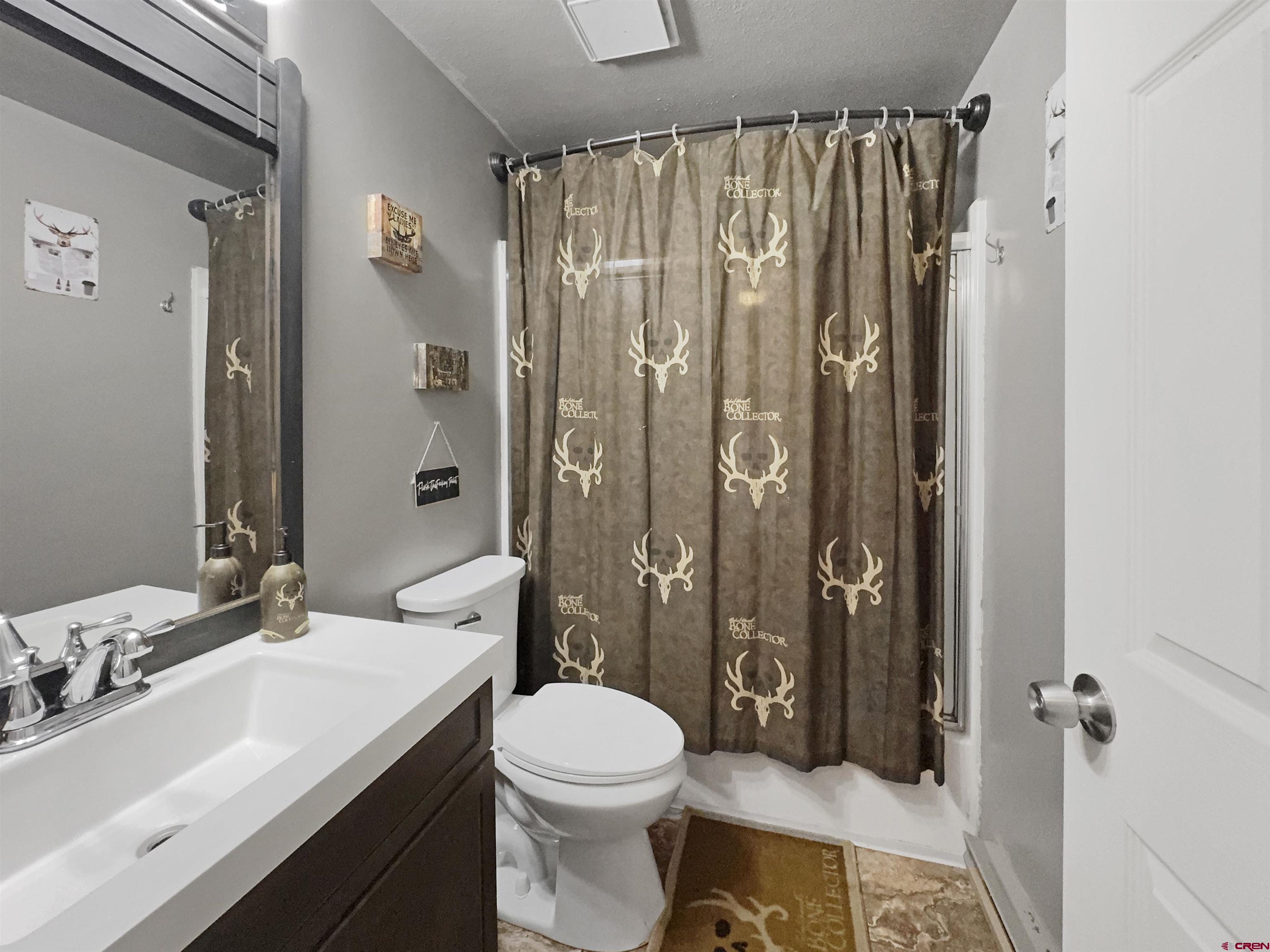 8 West 10th Street Cortez, CO 81321 - Photo 14 of 24 a bathroom with a sink a toilet a mirror and shower