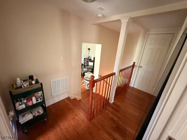 a view of a hallway with wooden floor and stairs
