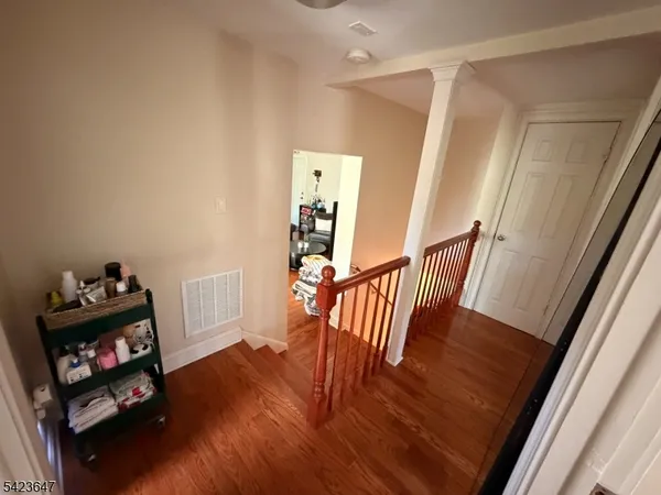 a view of a hallway with wooden floor and stairs