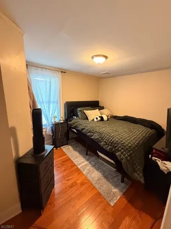 a spacious bedroom with a bed and wooden floor