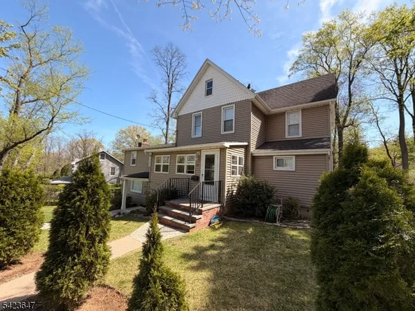 a front view of house with yard and trees around