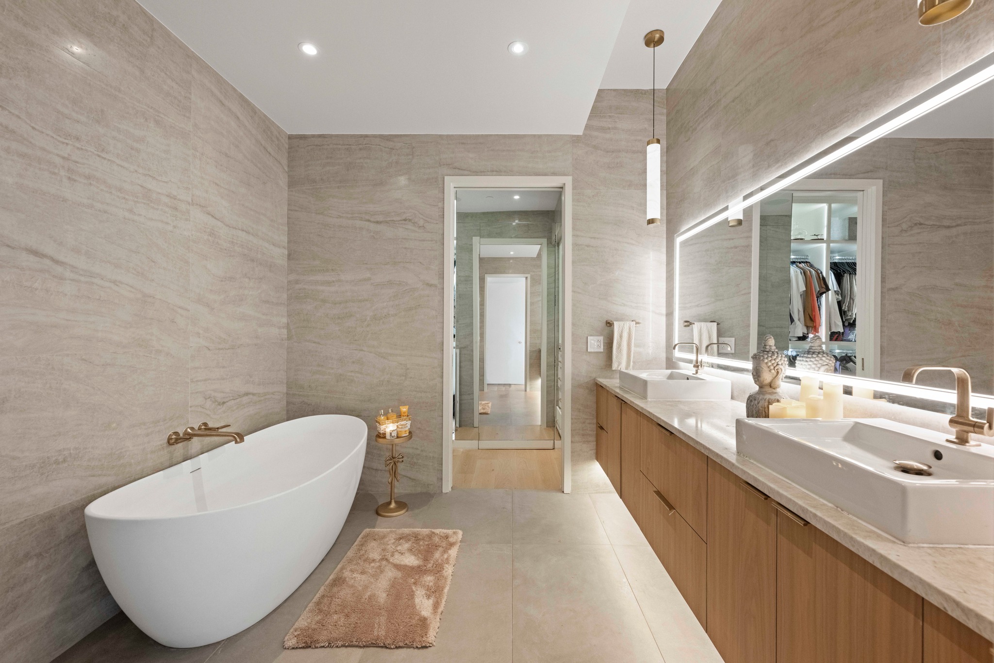 210 Lavaca Street, Unit 2706 Austin, TX 78701 - Photo 11 of 32 Dual vanity with undermount lighting, integrated rectangular sinks, and wall-mounted brass fixtures