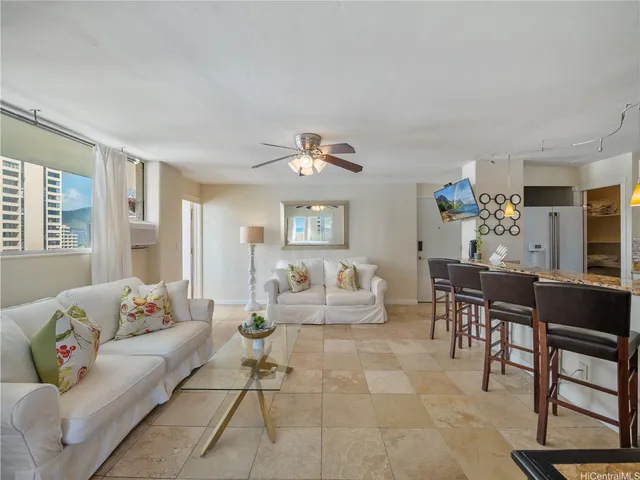a living room with furniture and view of kitchen