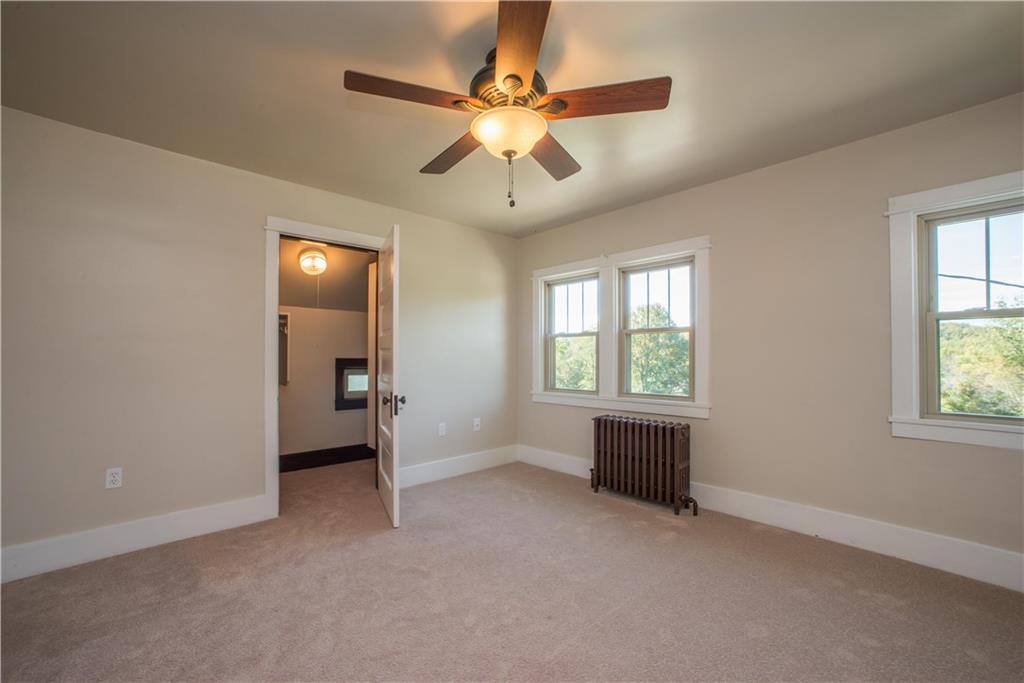 172 Bellbridge Road Elizabeth, PA 15037 - Photo 17 of 25 Reverse angle view of the second bedroom showing the interior of the walk-in closet with built-ins, ceiling fan, and windows overlooking the right side of the home.