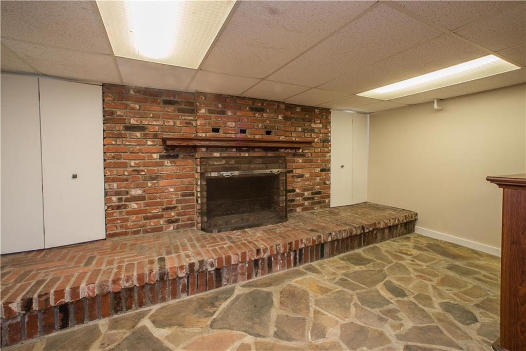 172 Bellbridge Road Elizabeth, PA 15037 - Photo 19 of 25 The brick fireplace on the lower level is wood-burning, and offers storage on both sides. This section of the gameroom has flagstone flooring, lending a rustic charm to the space.