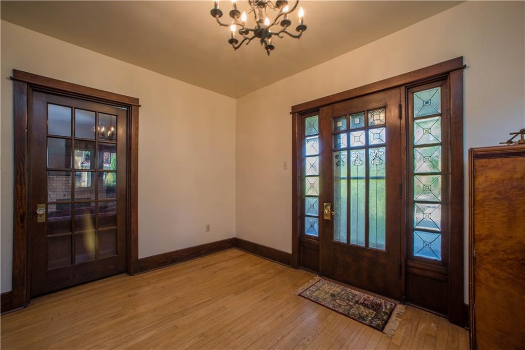 172 Bellbridge Road Elizabeth, PA 15037 - Photo 3 of 25 The spacious foyer offers exposed hardwood floors, neutral wall tones, and original wood door and baseboard trim which has been fully refurbished and stained in warm and rich hues. The chandelier shown here remains with the sale.