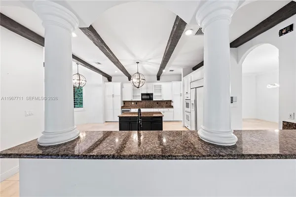 a large kitchen with stainless steel appliances kitchen island granite countertop a stove and a sink