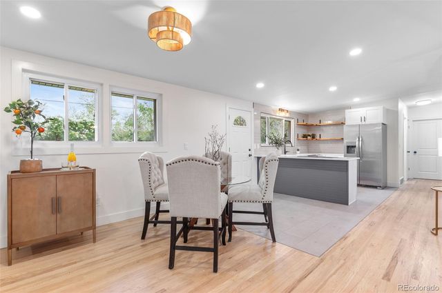 a view of a dining room with furniture a rug and wooden floor