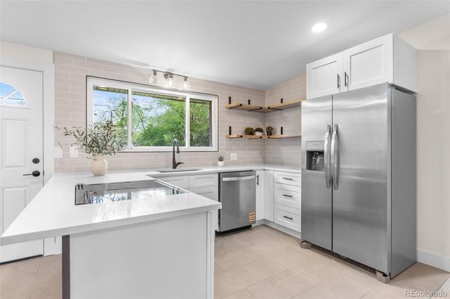 a kitchen with white cabinets and white appliances
