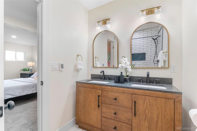 a en suite bathroom with double vanity a sink and a mirror