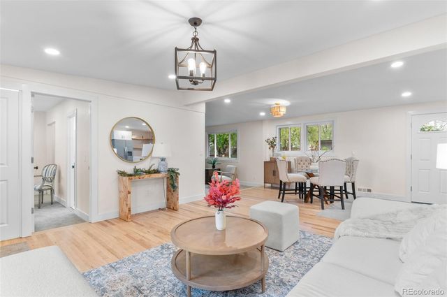 a living room with kitchen island furniture and a chandelier