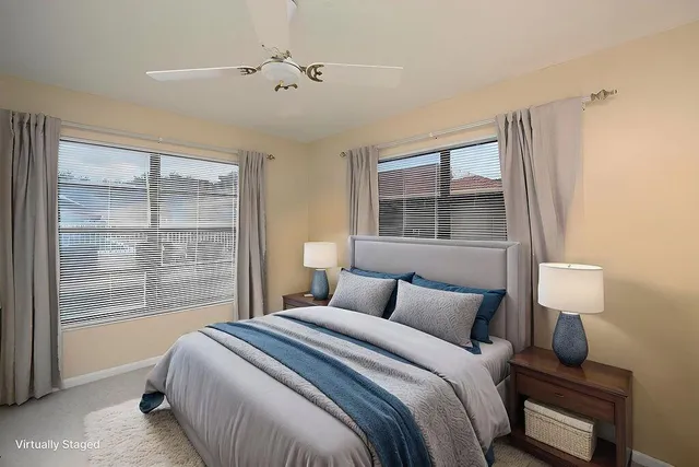 a bedroom with a large bed and a lamp next to a window