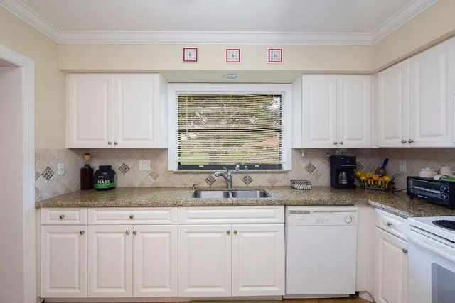a kitchen with white cabinets and white appliances