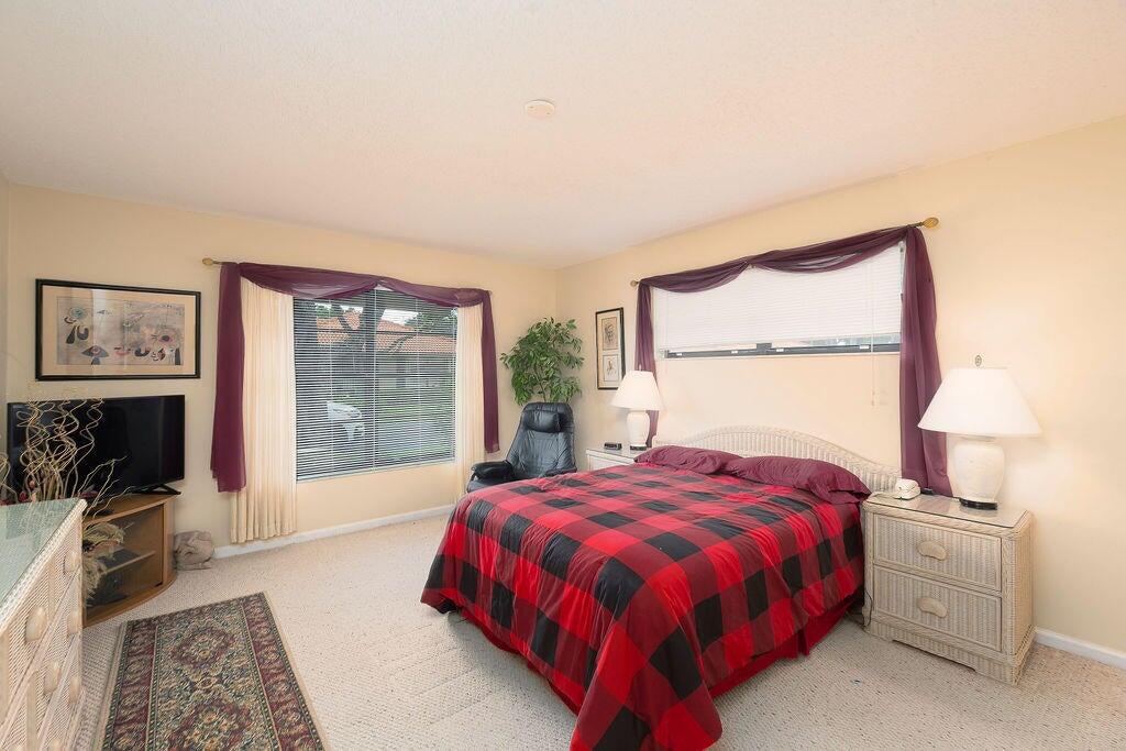 4600 Wildwood Tree Lane, Unit A Boynton Beach, FL 33436 - Photo 7 of 30 a bedroom with a bed and a flat screen tv