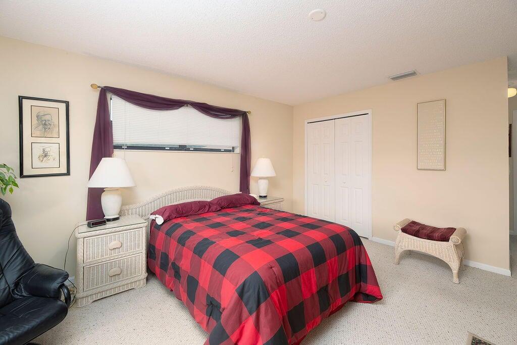 4600 Wildwood Tree Lane, Unit A Boynton Beach, FL 33436 - Photo 8 of 30 a bedroom with a bed and a chair