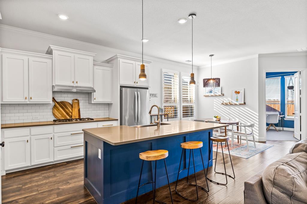 a kitchen with stainless steel appliances granite countertop a sink a stove and a wooden floors