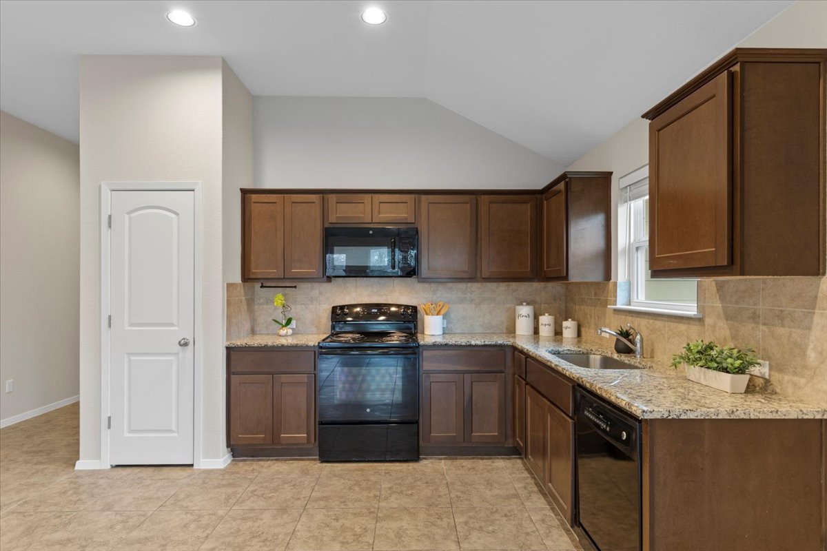 123 Saranac Drive Elgin, TX 78621 - Photo 8 of 27 The kitchen showcases granite countertops and ample cabinet storage.