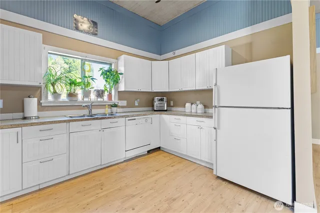a kitchen with white cabinets and white appliances